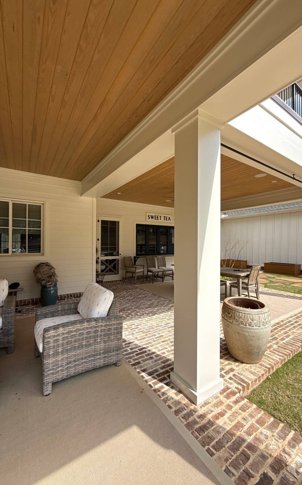 Freshly painted covered porch with white columns and exterior siding