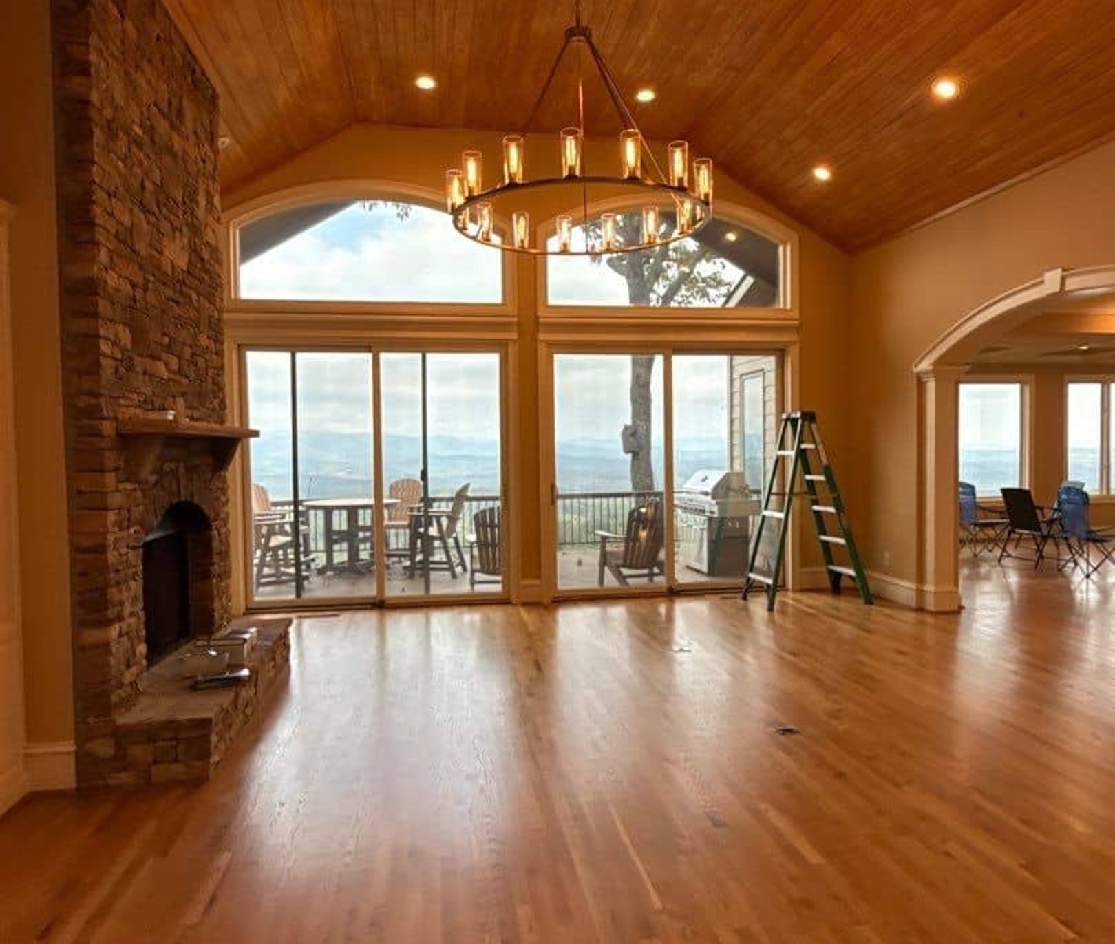 Freshly painted interior of a mountain home with wood plank ceiling and stone fireplace